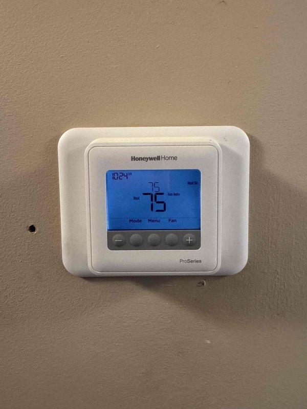 Performed heating maintenance service on system with Honeywell Home ProSeries thermostat. Verified thermostat is functioning correctly with heat setpoint at 75°F matching current temperature. Inspected burner assembly components and confirmed proper operation of heating system.