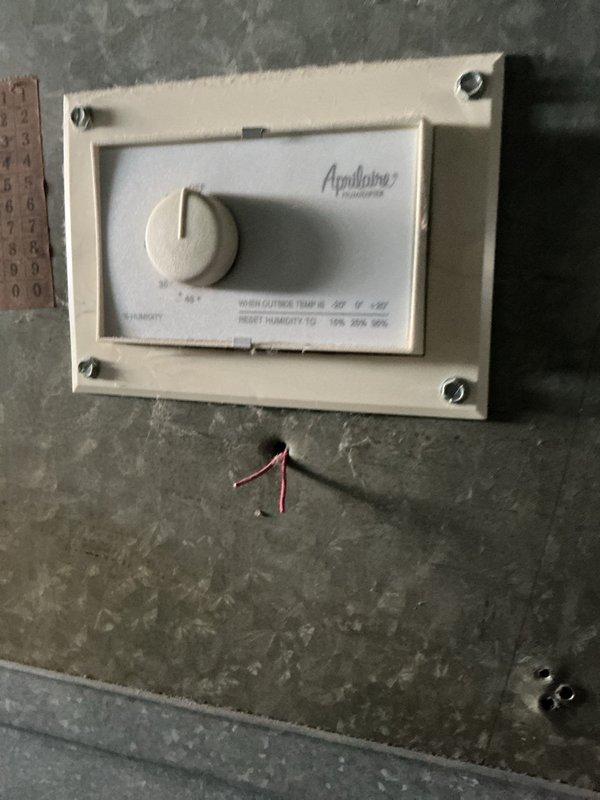 Performed routine heating maintenance inspection. Inspected Aprilaire humidistat mounted on concrete wall, checking wiring connections and functionality. Examined internal control board and wiring harness of heating system, verifying proper connections of multi-colored control wires to ensure proper system operation.