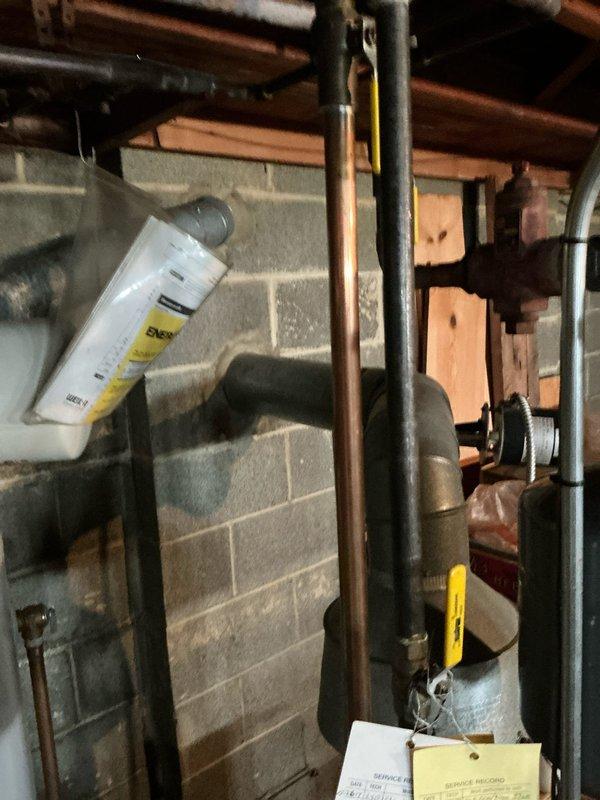 Conducted site assessment of existing boiler system in basement utility area. Inspected copper piping infrastructure, water tank with insulation, and examined connection points with visible tags. Documented condition of ventilation components and electrical connections to provide comprehensive replacement estimate.