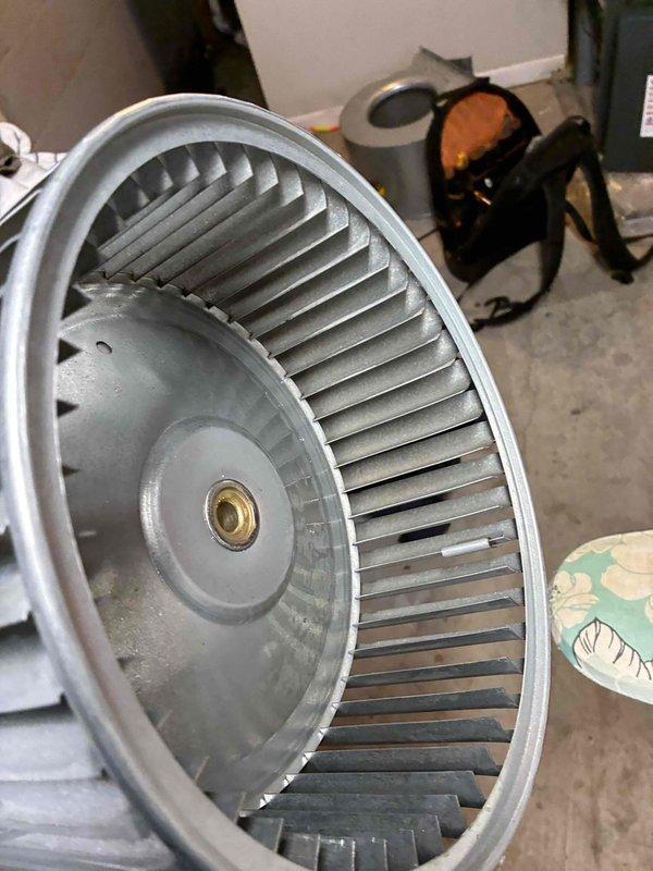 Completed blower wheel cleaning service on HVAC system. Removed the metal impeller assembly from housing, thoroughly cleaned all curved fins and central hub to remove accumulated debris and dust, then reinstalled component to restore proper airflow and system efficiency.