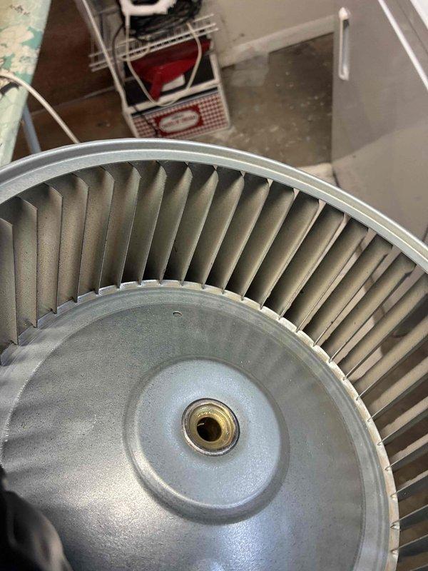 Completed blower wheel cleaning service on HVAC system. Removed the metal impeller assembly from housing, thoroughly cleaned all curved fins and central hub to remove accumulated debris and dust, then reinstalled component to restore proper airflow and system efficiency.