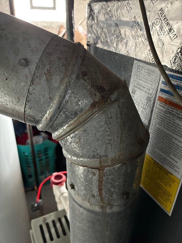 Performed detailed inspection of existing HVAC system for replacement options with customer. Documented significant corrosion and rust formation at duct seam connections, particularly at 90-degree elbow joints. Identified deteriorating flexible duct insulation and evaluated current system configuration including air handler connections and refrigerant lines for proper replacement specifications.