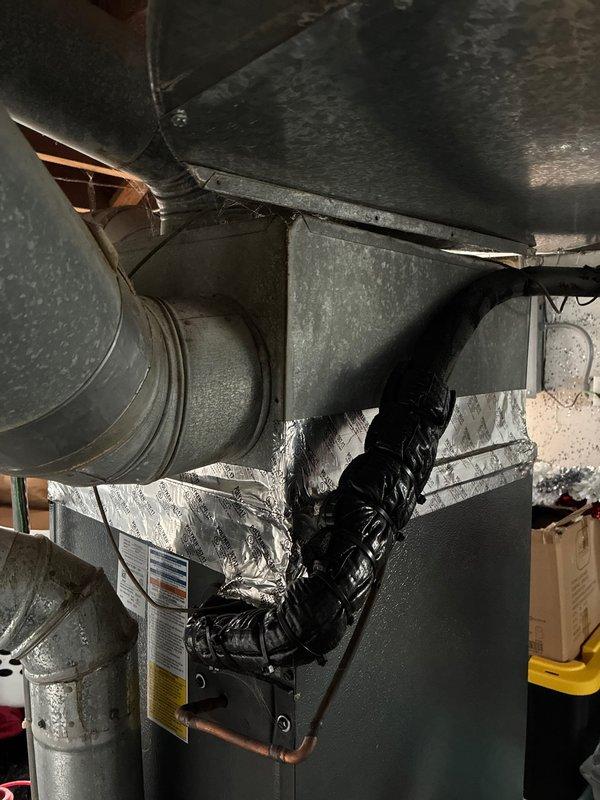 Performed detailed inspection of existing HVAC system for replacement options with customer. Documented significant corrosion and rust formation at duct seam connections, particularly at 90-degree elbow joints. Identified deteriorating flexible duct insulation and evaluated current system configuration including air handler connections and refrigerant lines for proper replacement specifications.