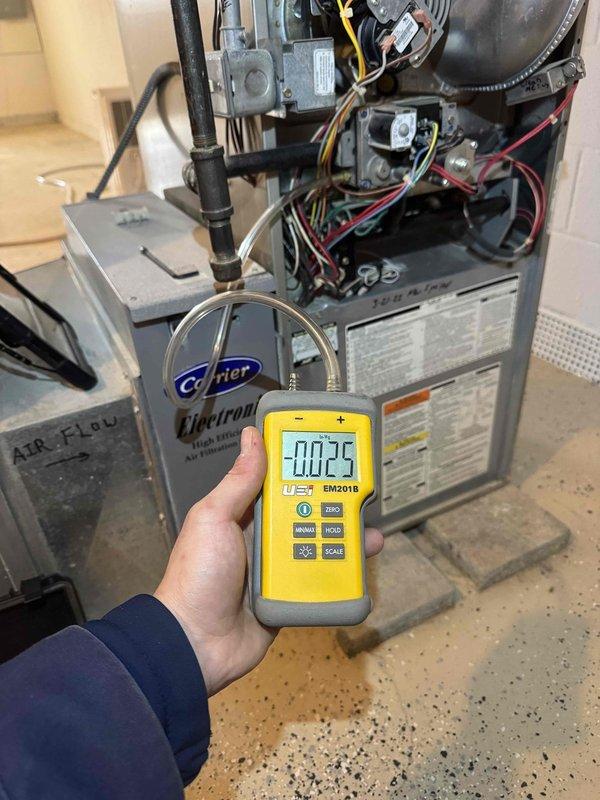 Conducted diagnostic inspection on aging Carrier HVAC system with reported no-heat condition. Performed pressure testing using UEI BM201B manometer (reading -0.02) to evaluate system functionality. Inspected furnace components including control board, wiring connections, and Electronic Air Filtration system, with particular attention to airflow measurements through the existing ductwork configuration.