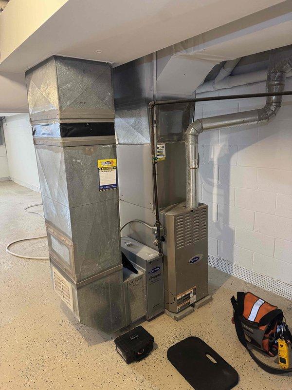 Conducted diagnostic inspection on aging Carrier HVAC system with reported no-heat condition. Performed pressure testing using UEI BM201B manometer (reading -0.02) to evaluate system functionality. Inspected furnace components including control board, wiring connections, and Electronic Air Filtration system, with particular attention to airflow measurements through the existing ductwork configuration.