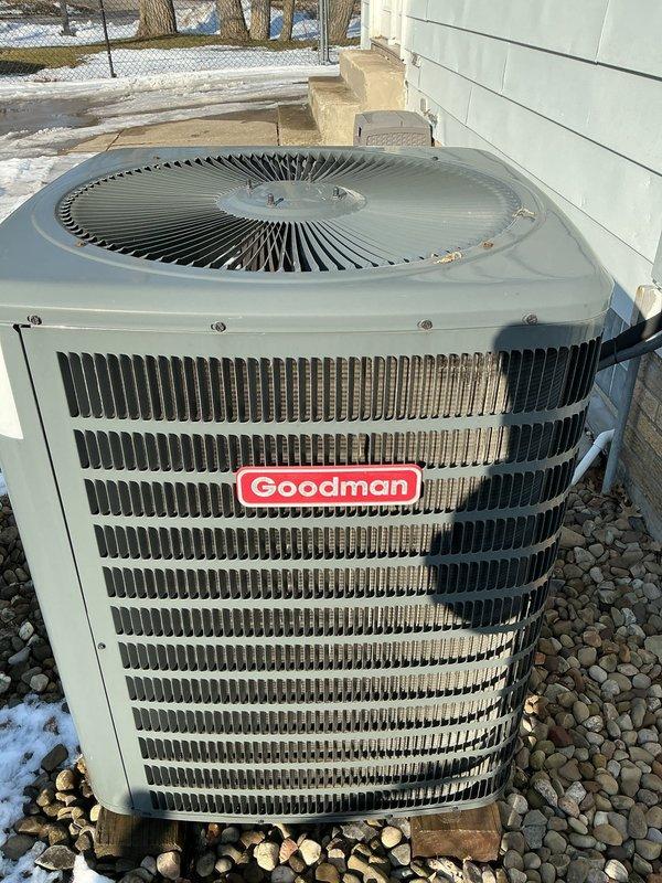 Completed preventative maintenance on Goodman heating system. Inspected outdoor condenser unit, which was properly mounted on platform with adequate clearance and functioning normally. No issues identified with electrical connections or system operation.
