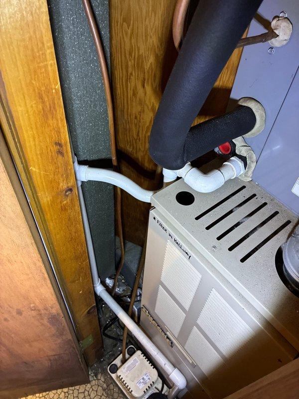 Conducted inspection and prepared estimate for replacement of existing HVAC unit located in utility closet with wooden enclosure. System includes black insulated refrigerant lines, PVC drainage, and copper tubing connections. Also evaluated electrical sub-panel labeled "MAIN HOUSE A/C UNIT" showing signs of aging with potential upgrade requirements to support new system installation.