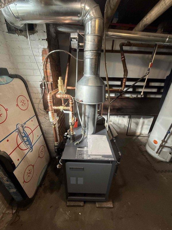 Completed installation of Ruud boiler system in basement with proper ductwork, copper piping, and valve connections. Performed measurements of existing cast iron radiator (26-42 inches) to ensure compatibility with new system. All connections tested and system functioning according to manufacturer specifications.