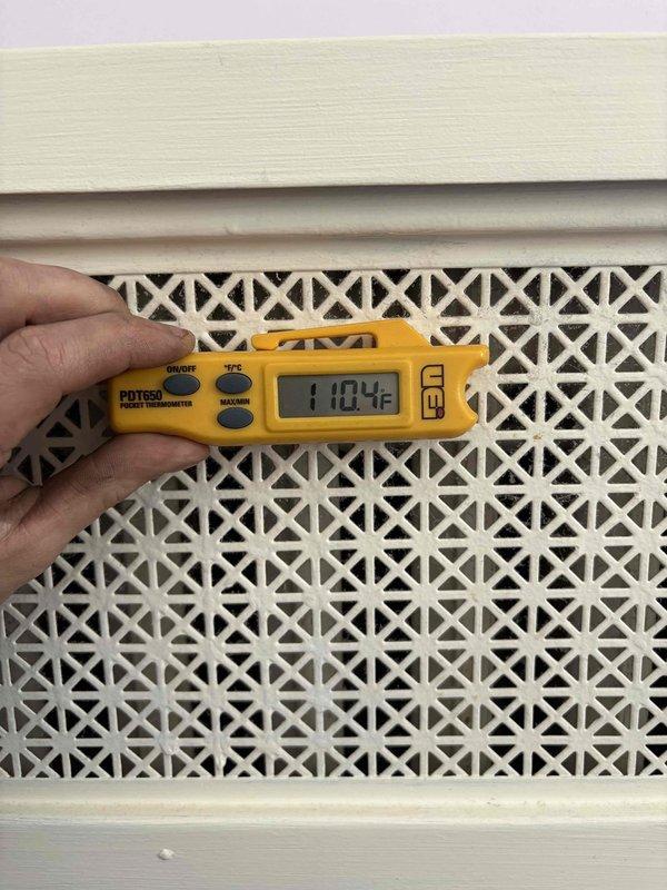 Completed boiler service finance agreement. Conducted temperature diagnostics with PDT650 thermometer, measuring supply air temperature (110.4°F) at decorative lattice vent and checking refrigerant line temperature (5.3°) for proper system operation. Documentation photos taken of all diagnostic points.