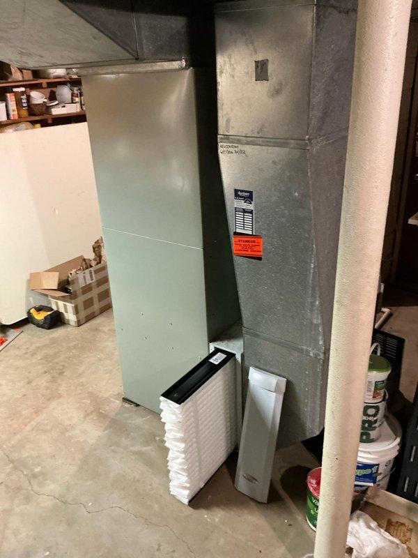 Inspected non-functioning furnace system in basement utility area. Identified complete system failure requiring replacement. Documented existing installation including galvanized ductwork, copper line connections, and current unit placement for proper replacement specifications.