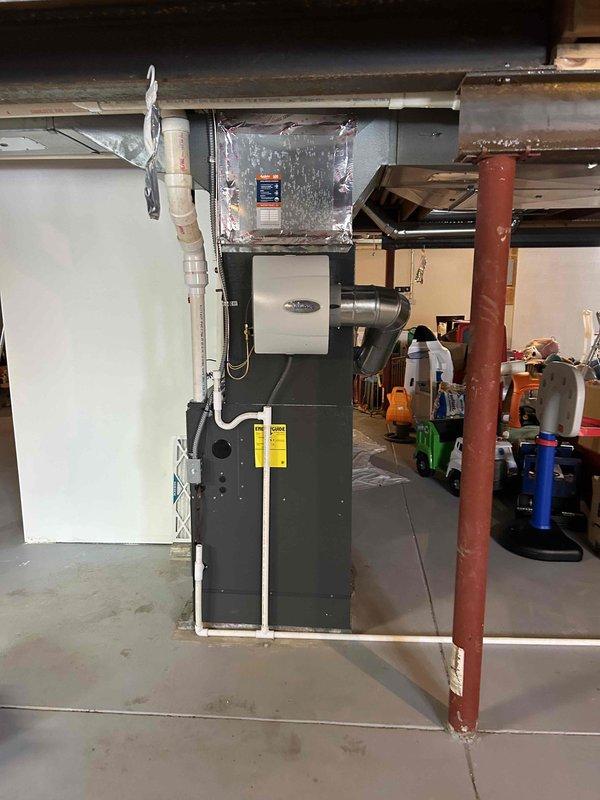 Successfully installed and commissioned a complete HVAC system consisting of a 96% efficient furnace with integrated air conditioning and humidifier. System includes properly sealed ductwork, PVC ventilation piping, and all necessary connections mounted on a concrete pad in the utility area.