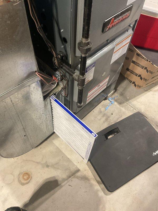 Responded to indoor air quality complaint regarding odor from forced heat system. Inspected furnace unit and ductwork in utility room, noting damp/burning smell reported by customer. Replaced air filter and checked for electrical issues; verified proper ventilation and operation of system to address reported IAQ concerns.