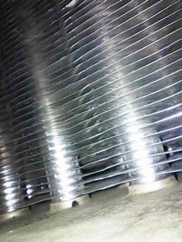 Performed scheduled heating maintenance on aging furnace system (10+ years old). Inspected heat exchanger and cooling fins, confirming components are clean and in good working condition with no visible damage. System includes proper PVC ventilation and connected ductwork with all safety labels intact.