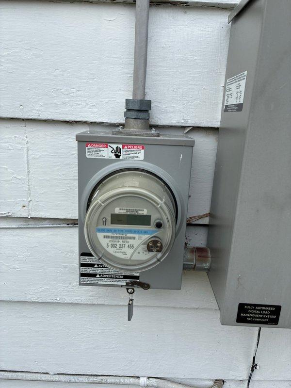 Conducted site evaluation for furnace and hot water tank replacement options. Inspected the electrical service panel to verify power supply capacity for potential system upgrades. Noted existing Honeywell ProSeries thermostat compatibility with proposed equipment. Photos documented current installation for proper sizing of replacement units.