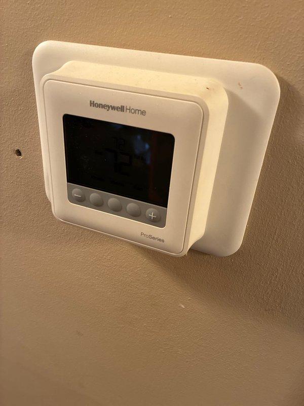 Conducted site evaluation for furnace and hot water tank replacement options. Inspected the electrical service panel to verify power supply capacity for potential system upgrades. Noted existing Honeywell ProSeries thermostat compatibility with proposed equipment. Photos documented current installation for proper sizing of replacement units.