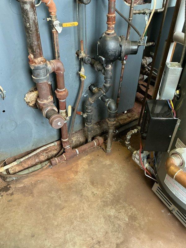 Conducted site inspection of non-operational steam boiler at church location. Examined existing HVAC ductwork in utility area and evaluated aging copper pipe system showing signs of corrosion and mineral buildup at multiple connection points. Documented current installation to prepare options for replacement of failing steam boiler system.