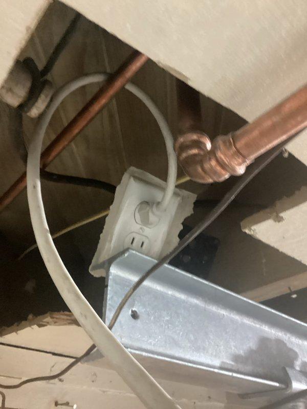 Completed site assessment for potential whole home rewire project, documenting existing electrical infrastructure including laundry room outlet strip with multiple connections and exposed wiring conduit. Inspected utility area revealing copper plumbing in proximity to electrical components, noting current outlet placement and wiring pathways that would need to be addressed in comprehensive rewiring plan.