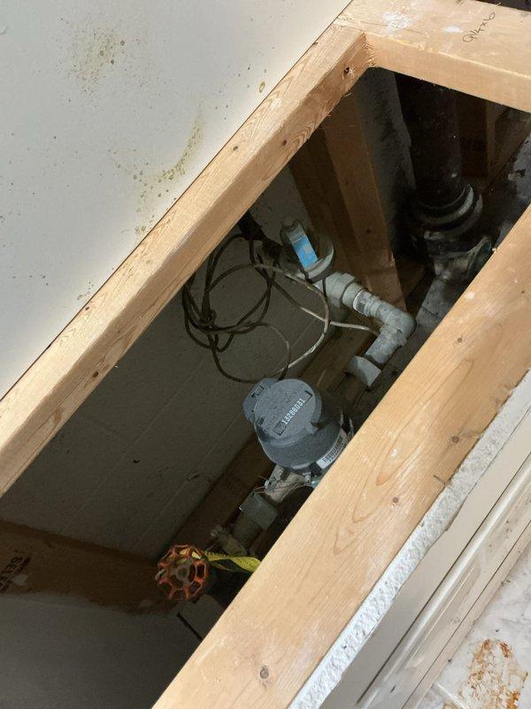 Conducted a thorough electrical inspection of the main breaker panel, documenting the condition of circuit breakers, wiring connections, and overall installation compliance. Additionally, examined the plumbing access panel containing a Sensus water meter, PVC piping, and shut-off valve, noting potential water damage on surrounding surfaces.