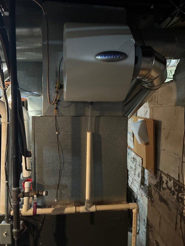Successfully completed installation of dual 96% efficiency furnaces with Aprilaire humidifiers in basement utility area. System includes properly connected sheet metal ductwork, PVC venting, and all necessary electrical connections. Final inspection confirmed proper operation of both heating units and humidification systems.