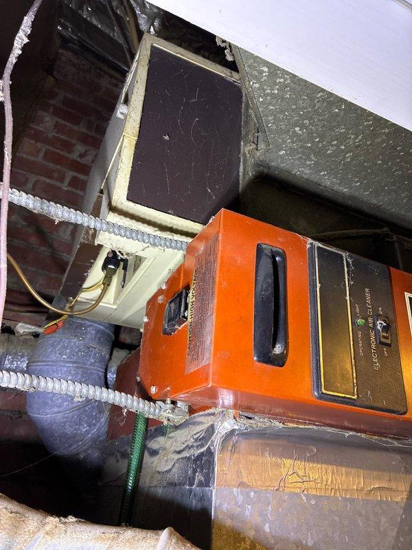Performed diagnostic inspection on heating system and identified cracked heat exchanger in existing furnace. Documentation includes photos of the control panel/equipment setup in utility area and damaged insulation with torn foil covering in the ductwork. Customer was presented with replacement furnace options to address this critical safety issue.