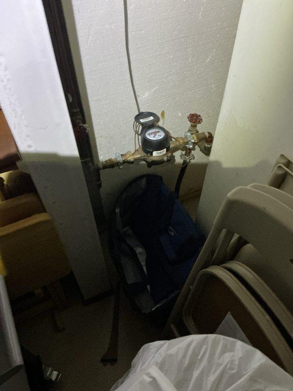 Conducted mid-morning electrical inspection of residential property. Verified water meter installation and surrounding plumbing components in utility area. Tested bathroom electrical outlet using outlet tester to confirm proper wiring and functionality.