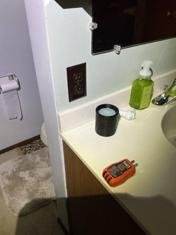 Conducted mid-morning electrical inspection of residential property. Verified water meter installation and surrounding plumbing components in utility area. Tested bathroom electrical outlet using outlet tester to confirm proper wiring and functionality.