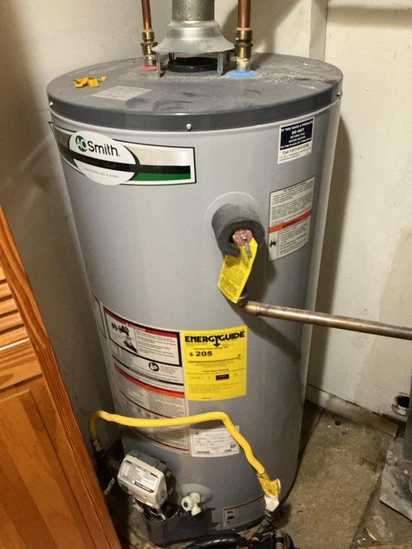 Performed routine maintenance service on A.O. Smith water heater system. Inspected copper hot/cold water lines, brass fittings, and central galvanized vent pipe for proper connections and signs of wear. Verified unit was functioning correctly with no visible damage or deterioration to tank or plumbing components.