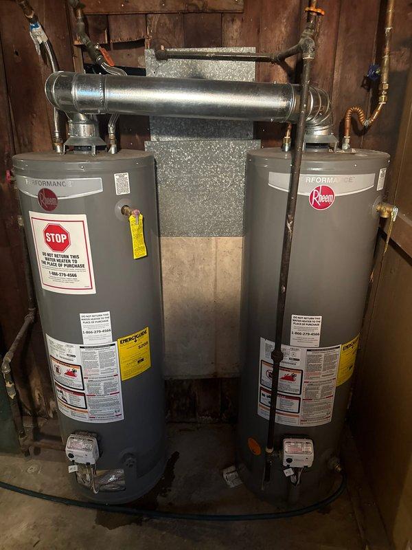 Conducted mid-morning inspection of dual Rheem water heater system. Observed significant corrosion and mineral buildup at connection points of the copper flex line, particularly at the U-bend section. Noted green-blue oxidation on brass fittings and documented condition of both units, including proper venting configuration and overall installation against wooden wall paneling. Photographic documentation completed.