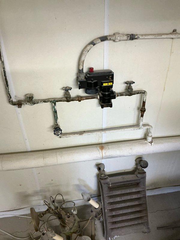 Conducted comprehensive inspection of aging boiler system with visible corrosion and rust staining on surrounding wall surfaces. Evaluated Honeywell VAPORSTAT control unit, noting condition of differential and main pressure gauges, wiring connections, and associated piping network. Provided customer with multiple replacement boiler options suitable for the existing configuration.