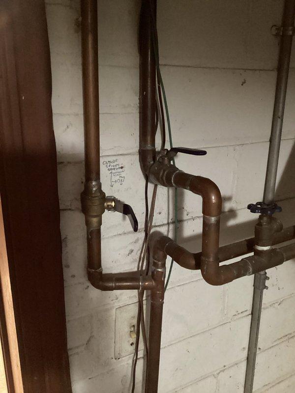 Responded to emergency service call for tanked water heater failure resulting in complete water loss to residence. Inspection revealed compromised water supply connections with visible leakage evident at exterior wall penetrations. Replaced faulty shut-off valves and restored copper supply lines to proper function, successfully restoring water service to the entire home.
