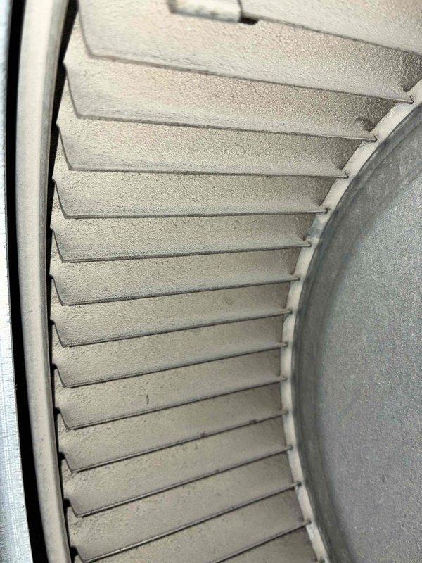 Responded to service call for furnace producing metal grinding noise. Inspection revealed significant dust accumulation on the blower wheel assembly and housing. Cleaned blower wheel fins and surrounding components to restore proper operation and eliminate noise.