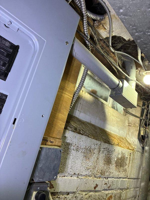 Performed inspection of damaged HVAC system affected by weather-related issues. Documented extensive water damage and discoloration on concrete block walls in utility area where electrical panel and HVAC components are installed. Observed possible mold/mildew growth indicating ongoing moisture problems that have compromised the air handler and associated ductwork. Provided replacement options for the weather-damaged AC system.