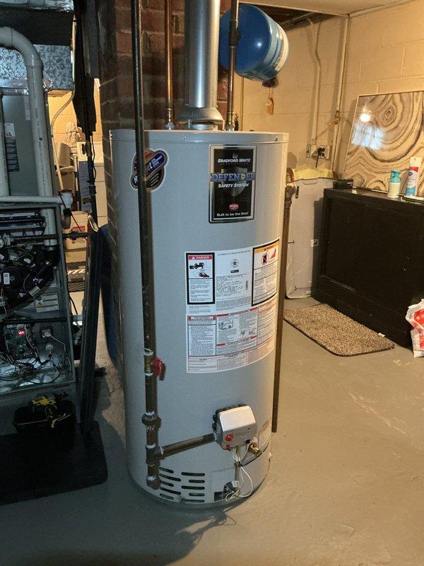 Performed scheduled maintenance on residential heating system. Inspected furnace unit with connected ductwork and PVC venting, ensuring proper operation. Also examined adjacent water heater with exhaust system and associated mechanical components, confirming all systems are functioning within normal parameters.