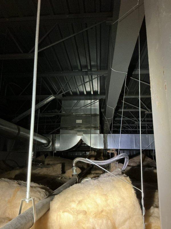 Responded to follow-up service call regarding persistent noise from commercial furnace system. Inspected attic space to evaluate previous technician's damper adjustment which had initially reduced noise. Identified additional resonance points in the flexible metal ductwork and secured loose connections between the main trunk and distribution boxes, successfully eliminating the noise complaint.