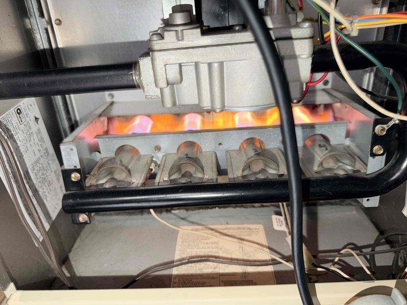 Performed monthly heating maintenance service on HVAC system. Inspected burner assembly and heat exchanger, noting normal dust accumulation but confirming proper flame characteristics and operation. System is functioning correctly with all electrical connections secure.