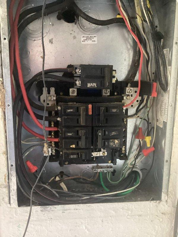 Conducted site assessment for EV charger installation, including evaluation of existing electrical panel capacity and load calculations. Panel inspection revealed an older service panel with limited available space; documented model RA1123 (serial D21H1157196) for compatibility verification with proposed charging equipment.