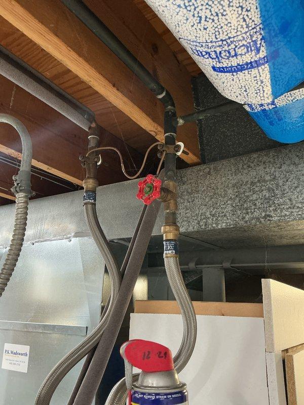 Performed comprehensive electrical panel inspection, documenting circuit breaker configuration and wiring condition. Noted multiple labeled breakers and examined wire routing within the panel. Also observed nearby plumbing infrastructure with particular attention to valve placement and mechanical components.