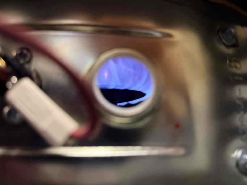 Inspected gas furnace and radiant floor heating system as requested. Verified proper flame pattern in burner with normal blue coloration, indicating correct combustion. Examined circulation pump, copper piping network, and pressure gauge components of the radiant floor heating system - all appear to be functioning correctly, contrary to customer report of system being disabled.