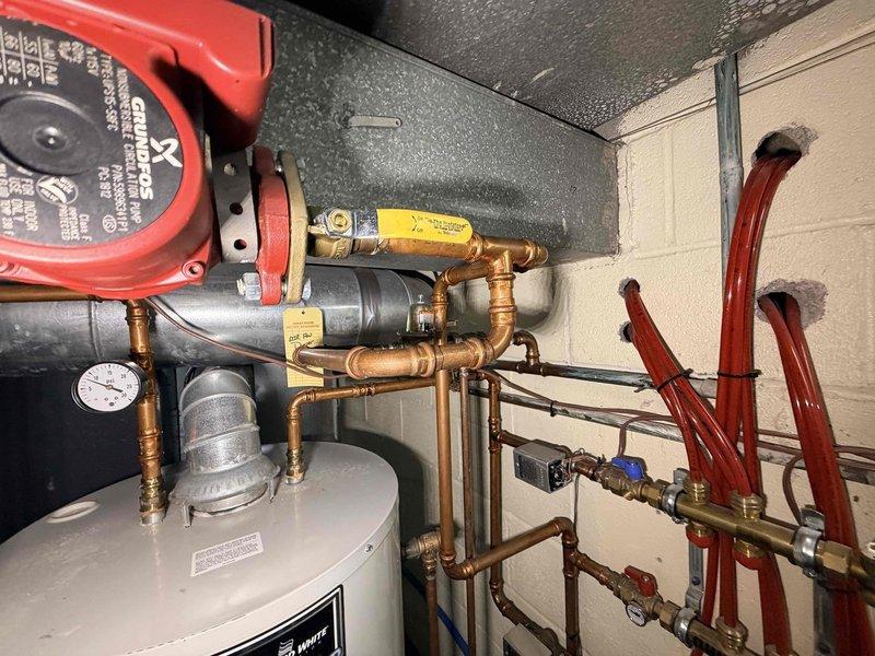 Inspected gas furnace and radiant floor heating system as requested. Verified proper flame pattern in burner with normal blue coloration, indicating correct combustion. Examined circulation pump, copper piping network, and pressure gauge components of the radiant floor heating system - all appear to be functioning correctly, contrary to customer report of system being disabled.