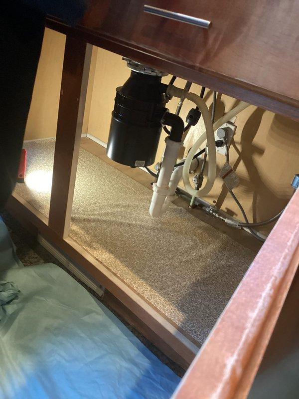 Successfully completed garbage disposal replacement service. Installed new black disposal unit with proper connections to existing white PVC drain system. Verified installation with no leaks and confirmed proper operation after service completion.