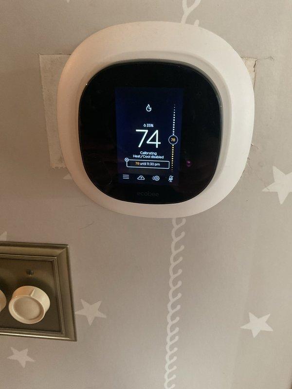 Responded to service call for non-functioning thermostat. Diagnosed and replaced faulty Ecobee smart thermostat with new unit. Successfully calibrated system and verified proper heating function with temperature display showing accurate readings and flame icon indicating normal operation.