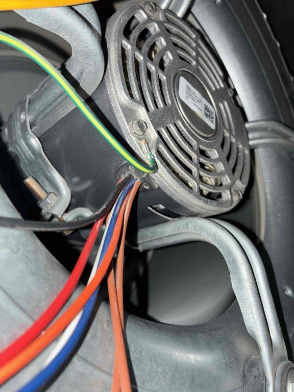Completed routine heating system maintenance including electrical testing with multimeter showing normal voltage readings (0.592V/0.094A). Inspected blower motor assembly and verified proper electrical connections to fan housing, with all wiring (including ground wire) secure and in good condition. System operating within normal parameters with no issues detected.