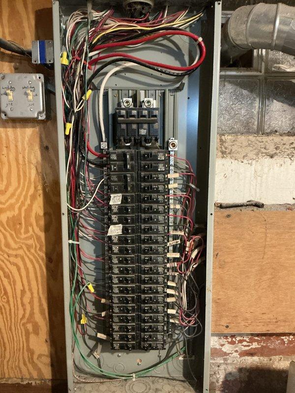 Conducted visual inspection of residential electrical system, documenting main breaker panel configuration with approximately 20-30 circuit breakers and associated wiring. Examined exterior meter installation, noting digital display functionality and connection points to service entrance conductors.