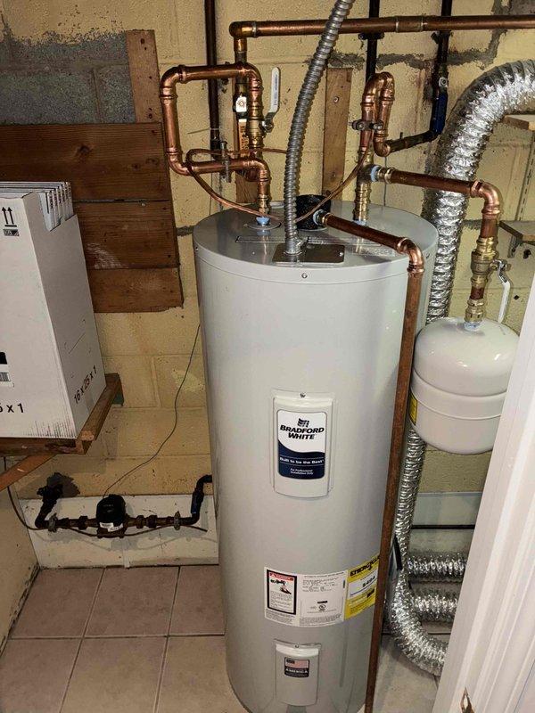 Successfully installed a 50-gallon Bradford White electric water heater with accompanying expansion tank in utility area. Completed all necessary copper piping connections with appropriate brass fittings and valves to integrate with existing plumbing system. System was tested and confirmed to be functioning properly with no leaks.
