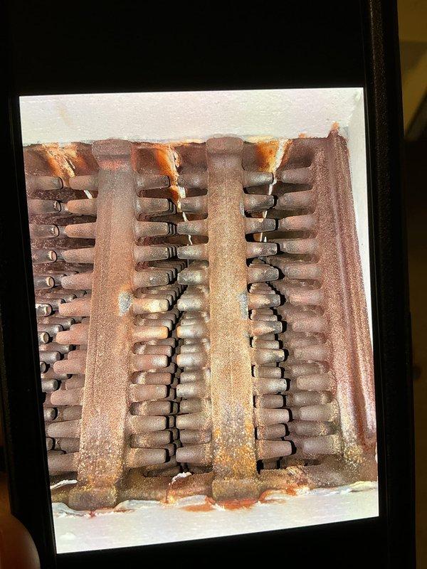 Performed scheduled boiler maintenance and identified significant corrosion on heat exchanger fins. System inspection revealed rust accumulation at connection points and a water leak near the furnace base. Documented condition with photos for future reference and discussed replacement options with property owner.