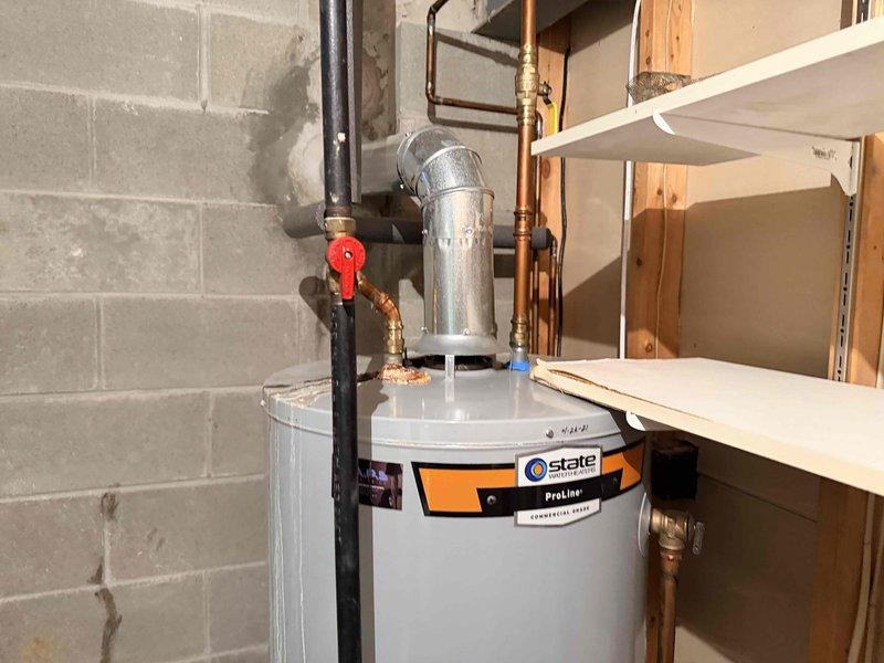 Responded to no heat service call for 10+ year old system that was completely non-operational. Upon inspection, determined service was actually needed for a State ProLine water heater installed in basement utility area. Observed proper connections including copper water lines and gas supply with functioning shut-off valve, but noted minor corrosion on some pipe fittings. System was restored to proper working condition.