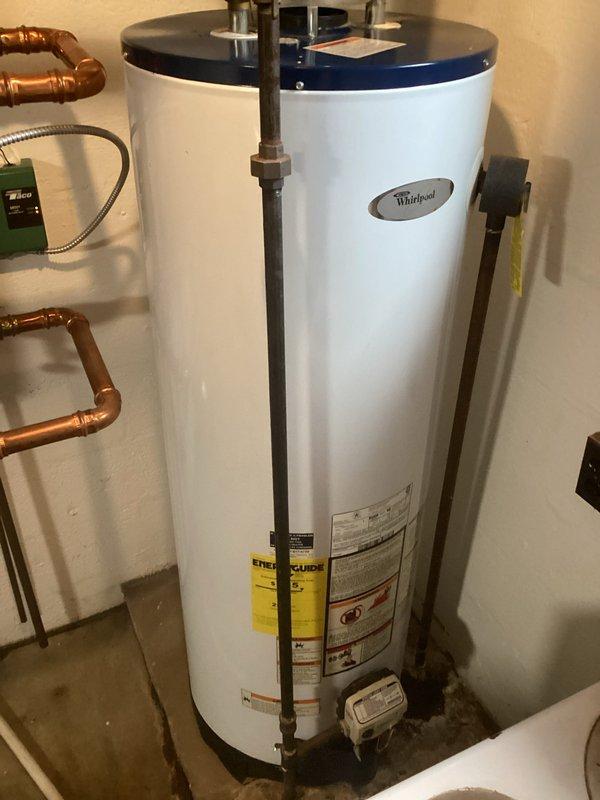 Performed regular maintenance service on Whirlpool tanked water heater system. Inspected all copper pipe connections, ventilation components, and control panel for proper functionality. Unit is operating within normal parameters with no leaks or issues detected at connections or tank base.