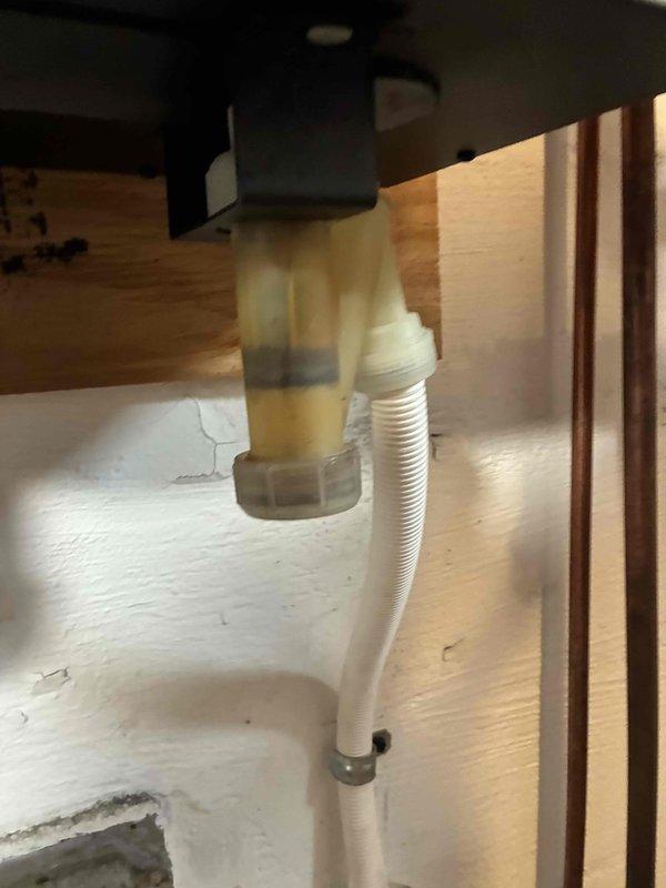 Performed routine heating maintenance inspection on boiler system. Examined pressure gauge on copper piping, confirming proper temperature and pressure readings within operational parameters. Inspected condensate drain assembly, noting aging in the translucent plastic fitting with mineral buildup and verifying proper drainage through the white flexible hose with secure clamp connection.