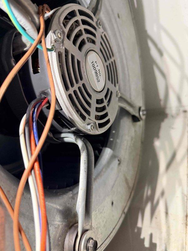 Performed routine heating maintenance on system. Inspected fan motor assembly and electrical connections, confirming proper wire routing through mounting bracket. All components appear to be in normal working condition with no signs of damage or abnormal wear.