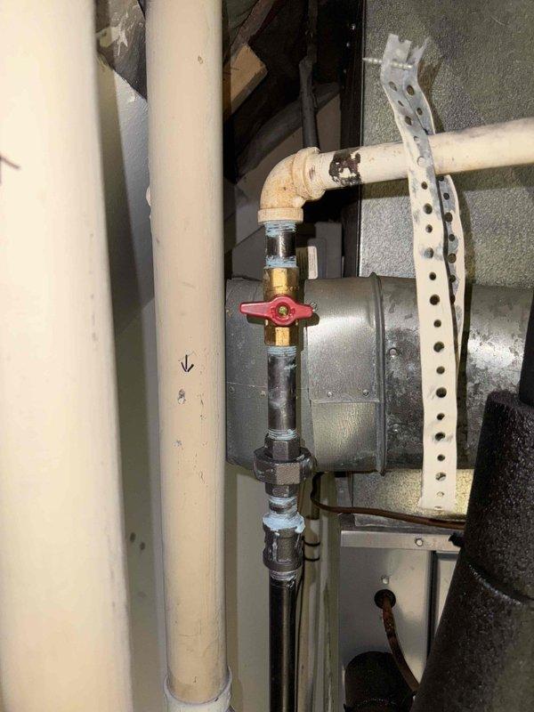 Responded to customer complaint of gas-like odor from furnace. Inspection revealed corrosion on gas pipe connections and fittings, particularly at the elbow joint. Documented oxidation and aging of cast iron pipes as well as condition of shut-off valve and PVC/metal pipe transitions in the utility area.